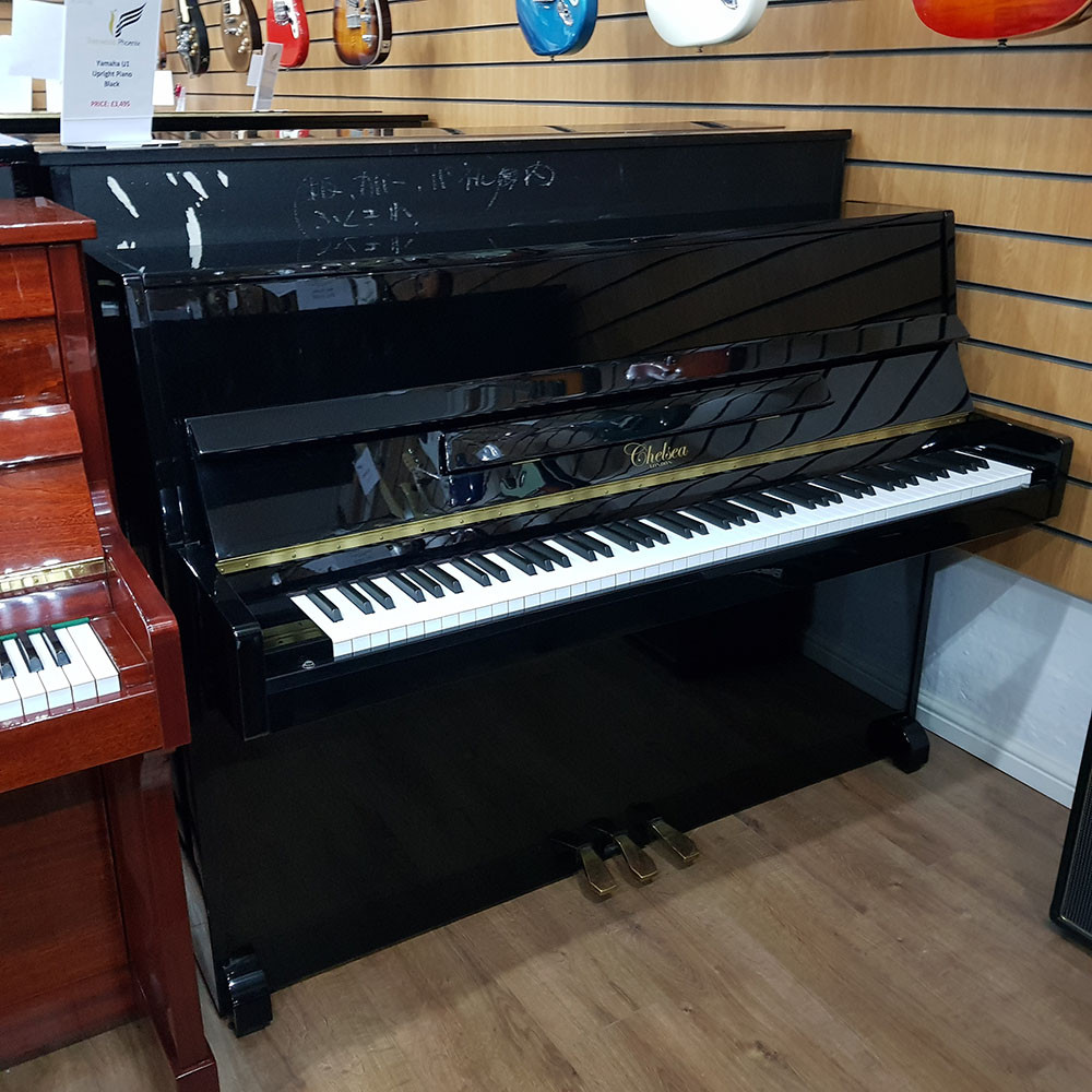 Used Chelsea 108 upright piano, in a black polyester case, for sale.