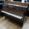 Used Karl Muller upright piano for sale, in a polyester mahogany case.